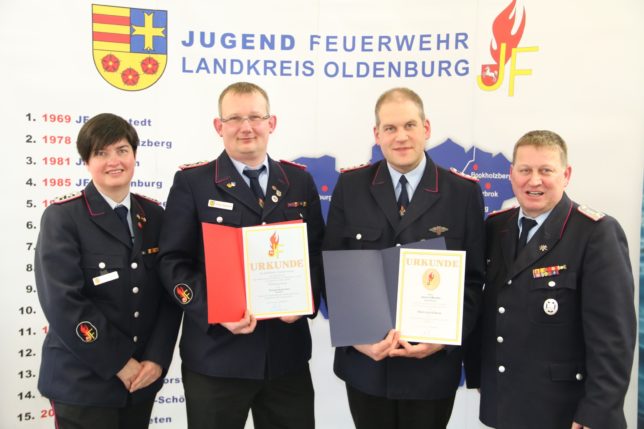 Thomas Heuermann (2.links) und Sascha Meister (2. Rechts) erhielten bei dem Kreisjugendfeuerwehrtag jeweils eine Ehrung von Werner Mietzon (rechts). Diane Febert gratulierte. / Bild: Bahrs